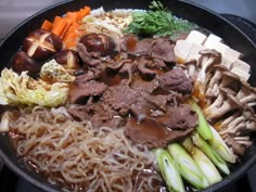 a bowl filled with noodles, meat and vegetables