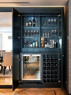 a wine cabinet with many bottles and glasses in it