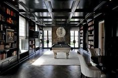 a large room with many bookshelves and a pool table