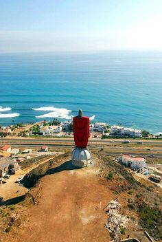 a person sitting on top of a large statue