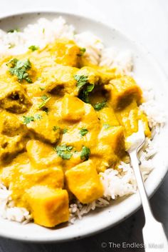 a white plate topped with rice and chicken curry