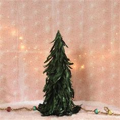 a fake christmas tree sitting in front of a pink wall