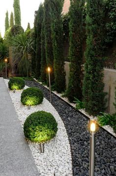 an outdoor garden with gravel and lights