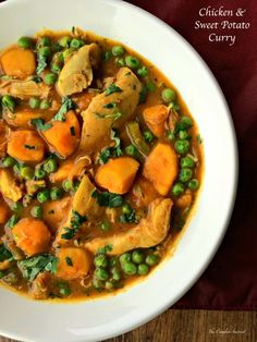 chicken and sweet potato curry in a white bowl on top of a wooden table with a red napkin