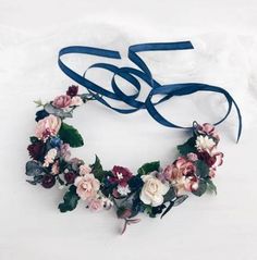 a blue ribbon is tied around a floral wreath