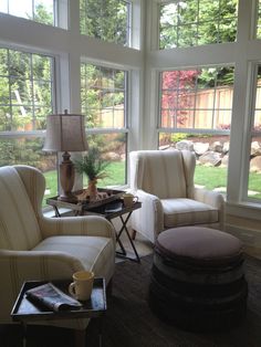 a living room filled with furniture and windows covered in lots of glass doors that look out onto the yard