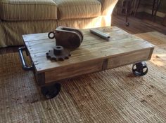 a coffee table made out of pallet wood with wheels on the bottom and one end