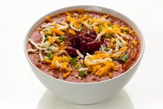 a white bowl filled with red beans, cheese and other toppings on top of it