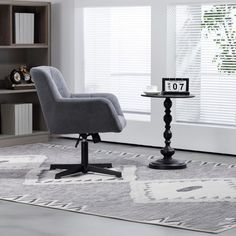 a living room with a gray chair and white rug on the floor, next to a book shelf