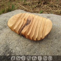 a wooden object sitting on top of a rock