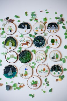 a collection of handmade coasters with trees and animals on them, surrounded by green leaves