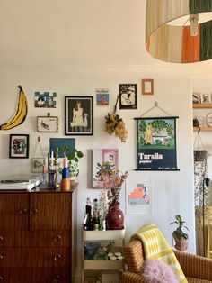 a living room filled with furniture and lots of pictures on the wall next to a dresser