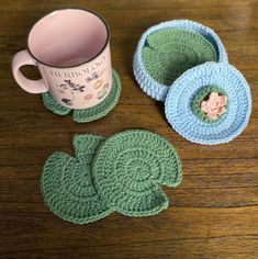 crocheted coasters and coffee cup holders on a wooden table with a mug in the middle