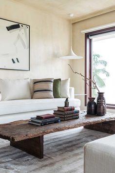 a living room filled with furniture and a painting hanging on the wall above it's windows