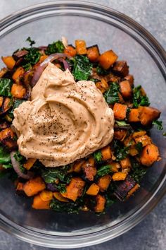 a glass bowl filled with vegetables and dressing