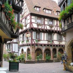 an old building with flowers on the windows and balconies in front of it