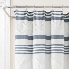 a white and blue striped curtain hanging on a rod