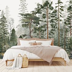 a bed sitting on top of a wooden floor in front of a forest wall mural