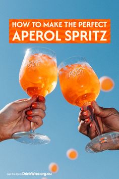 two people holding up wine glasses with the words how to make the perfect aperol spritz