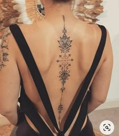 the back of a woman's neck with tattoos on her upper and lower back