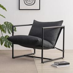 a black chair sitting on top of a wooden floor next to a potted plant