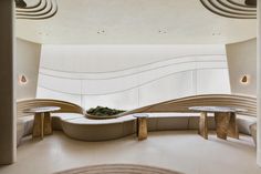 a curved room with benches and tables in it