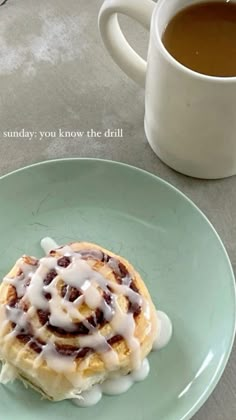 a blue plate topped with a pastry covered in icing next to a cup of coffee