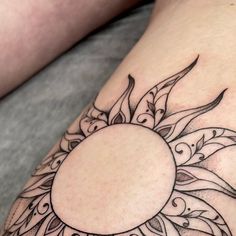 a woman's thigh with a sun tattoo on it