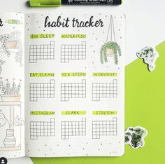 an open planner with stickers on it next to a green and white desk top