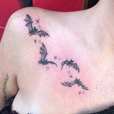 a woman's back with three bats and stars tattoo on her left side shoulder