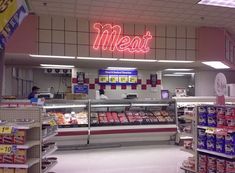 the inside of a deli with meat and cheeses on display in front of it