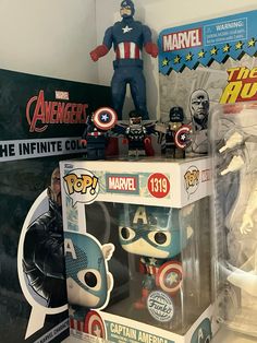 the captain america pop vinyl figure is on display in a box next to other collectibles