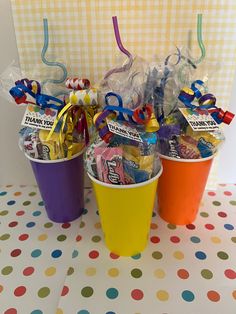 three buckets filled with candy on top of a table