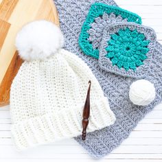 two crocheted hats are next to a cutting board