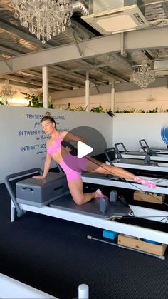 a woman in a pink leotard doing pivots on an exercise machine