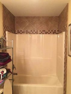 a bathroom with a toilet, shower and bathtub in the corner next to a tiled wall