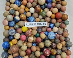 a pile of marbles with a sign that says rupp marbles on it