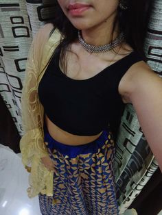 a woman in black top and blue skirt posing for the camera