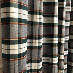 the curtains are lined up with plaid fabric