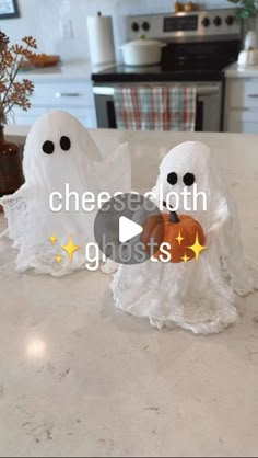 two white ghost figurines sitting on top of a counter