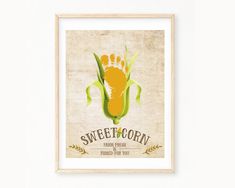 a framed poster with a baby's foot and the words sweet corn on it