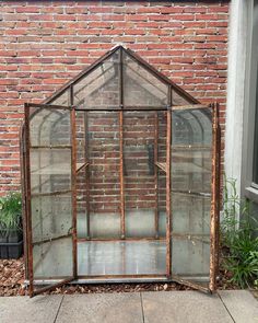 an old glass greenhouse sitting on the side of a building