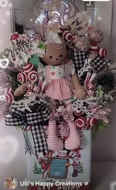 a teddy bear sitting on top of a box filled with candy canes