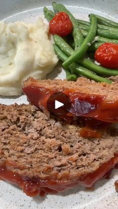 a plate with meatloaf, mashed potatoes and green beans