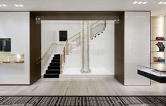 the inside of a store with white walls and wooden floors, glass display cases on either side