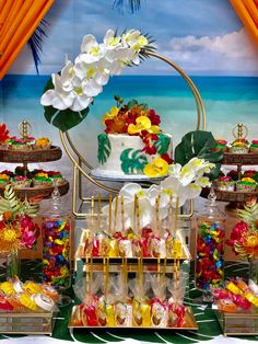 the dessert table is decorated with tropical flowers and candy bar wrappers for guests to eat