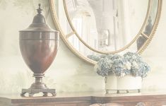 a dresser with a mirror and vase on it