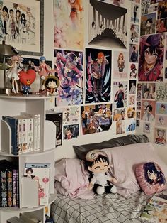 a bed room with a neatly made bed and lots of pictures on the wall above it