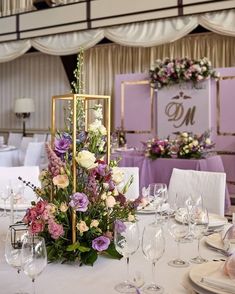 the table is set with white and purple flowers