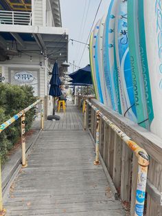 there are many surfboards lined up on the boardwalk near the beach side restaurant and bar